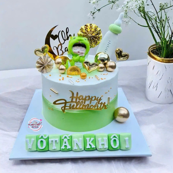 Bánh kem con rắn cho bé trai màu xanh lá trang trí em bé mặc đồ hình rắn, bình sữa và phụ kiện ánh kim mừng đầy tháng.
